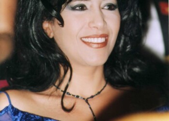 Ofra Haza smiling in a blue gown with necklace